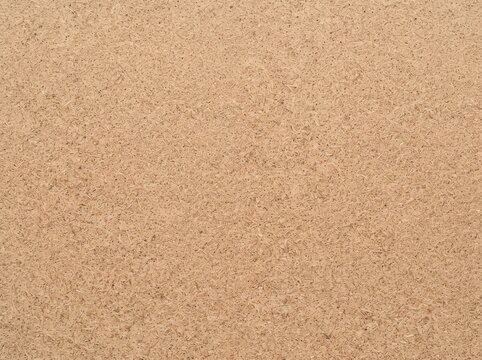 A close-up view of a light brown textured surface, resembling fine felt or fibrous material, providing a warm and natural background.