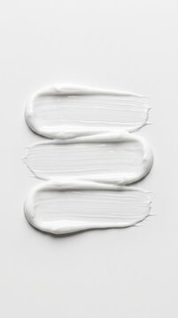 Three thick horizontal white paint strokes or cosmetic cream smears with visible brush texture and impasto ridges, isolated on a plain white background for graphic design use. 