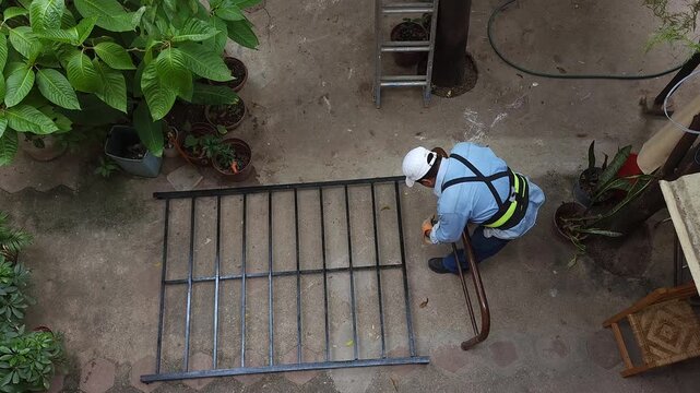 Young Man Assembling Metal Bed Frame Structure Outdoors