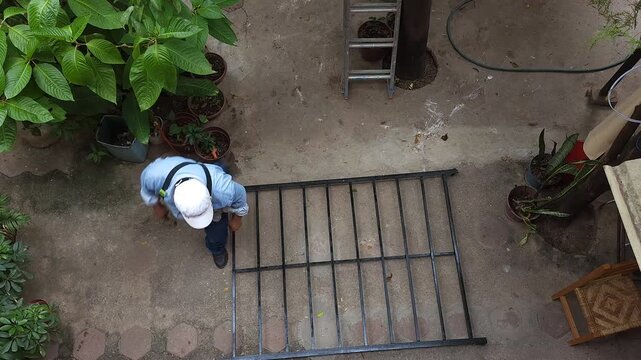 Young Man Pulling Repaired Iron Bed Frame Structure for Assembly