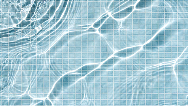 clear water ripples with bright light caustics over blue mosaic tiles on a swimming pool floor