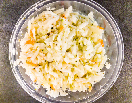 Polish coleslaw salad with horseradish dressing in a glass bowl, top view