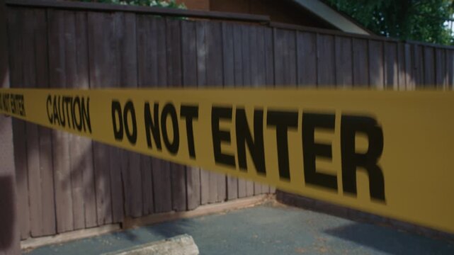 Yellow caution tape do not enter close up blocking unsafe area showing restricted access and control of hazardous outdoor zone