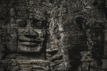 Fototapeta premium Close up of serene carved stone faces on the ancient towers of Bayon Temple at Angkor Thom in Siem Reap, Cambodia