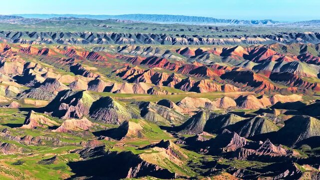 Aerial view of colorful danxia landform mountains and green valleys in Xinjiang, China.