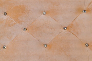 Obraz premium Beige Velvet Tufted Upholstery Texture with Diamond Rhinestone Buttons Pattern Background