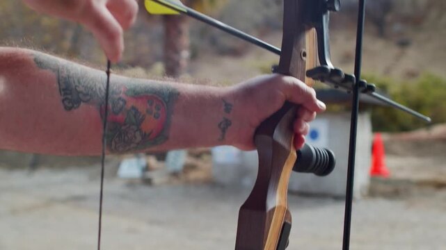 Archer Nocking Arrow and Aiming Recurve Bow at Outdoor Range