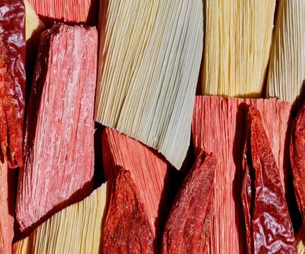 Dried corn husks and red chiles in a repeating flat lay pattern for traditional Latino cooking and Hispanic food editorials