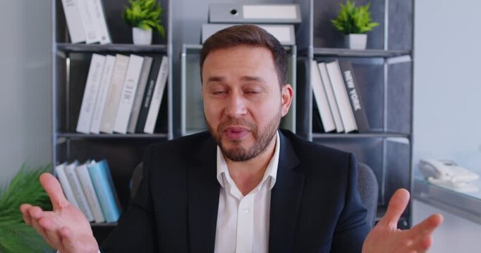 Portrait of a businessman working on online video call or conference during office meeting, talking via camera, focusing on communication in a professional setting with engagement.