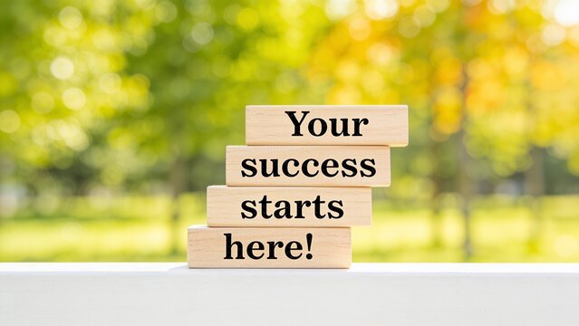 Motivational wooden block sign reading success starts here in bright outdoor setting