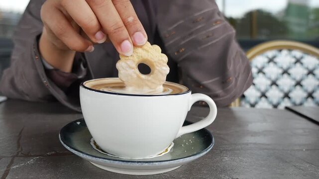 Enjoying coffee and cookie at a caf&eacute; in a city