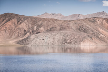Clear-water rivers and lakes in a mountain valley, pastures and green grassy fields set against mountain ranges and snow-capped, glacier-clad peaks—a scenic landscape background © Denis