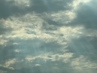 Obraz premium Heavenly Clouds With Dramatic Rays of Light Shining Through the Sky Above a Peaceful Landscape
