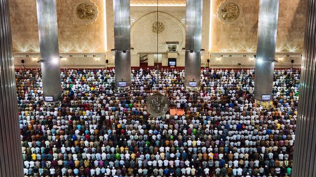 Asia, Indonesia, Jakarta, zoom out time lapse of Jakarta's Istiqlal mosque, with Muslims praying during Friday mass prayer. 