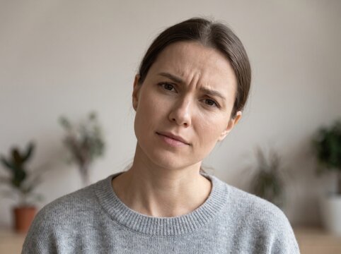 Portrait of Confused Young Woman Looking at Camera with Questioning Expression