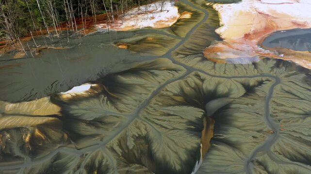 Aerial abstract surreal natural patterns above. Colorful chemical mining leach residues in decanting pond by drone