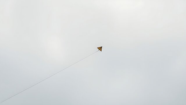 Broken kite string, kite drifting away in gray overcast sky, minimalist composition.