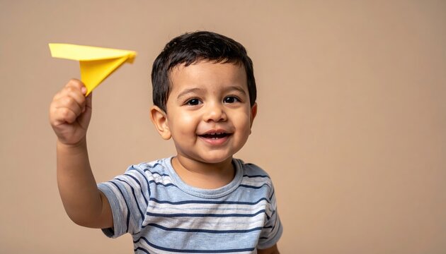 baby boy holding paper airplane smiling