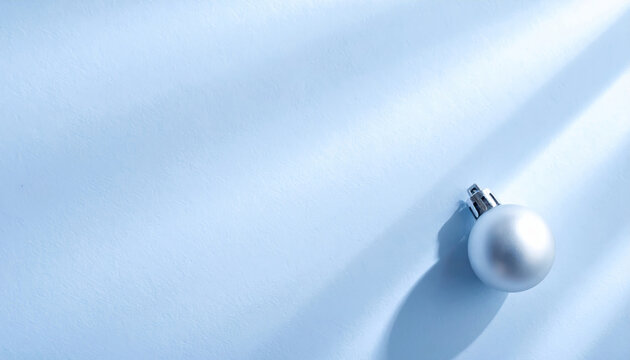 Soft blue holiday ornament on textured backdrop evoking calm winter elegance and soft shadows