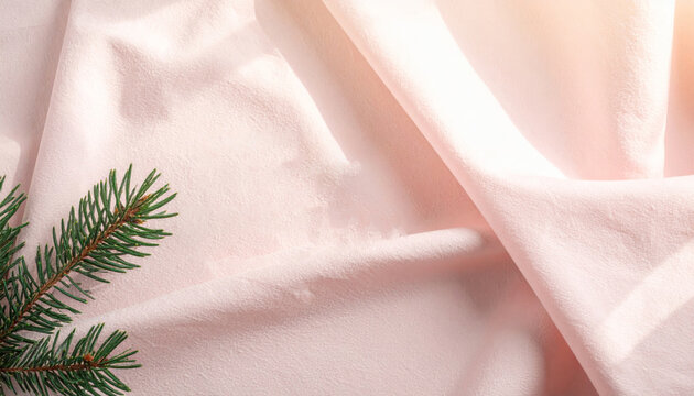 Pine branch on pink fabric background evoking soft festive calm and minimal holiday decor