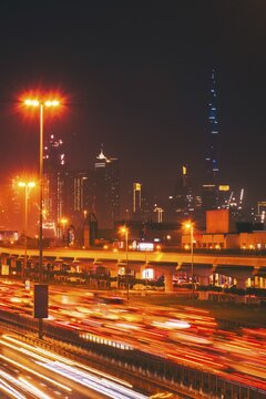 Panorama Dubai heavy night night traffic on Sheikh Zayed Road after work rush hour traffic. Light trails lead to the Burj Khalifa and Downtown Dubai cityscape at night landmarks skyline