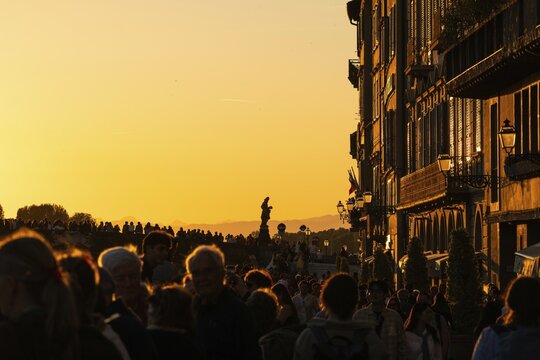 Crowd at sunset on the river Arno, light-filled evening mood, back light, old town, Florence, Tuscany, Italy