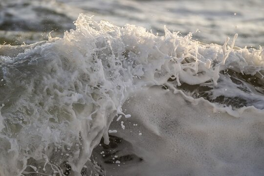 Surf, breaking wave against light, Sorteb&aelig;rdalen Strand, Houvig, North Sea, Denmark