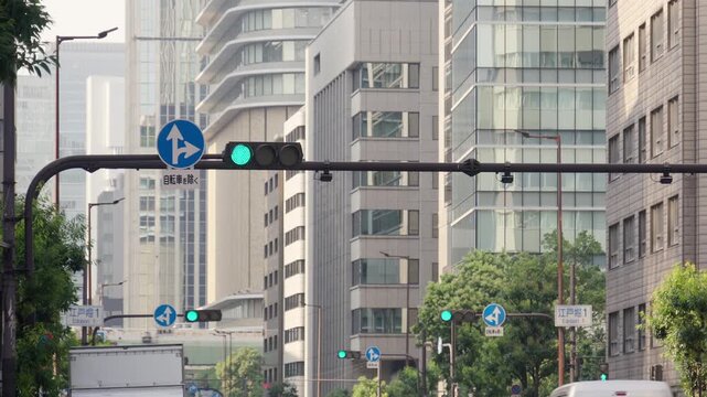 大阪・四つ橋筋の江戸堀周辺の街並み。青から赤へ変わる交通信号機と補助標識付きの道路標識