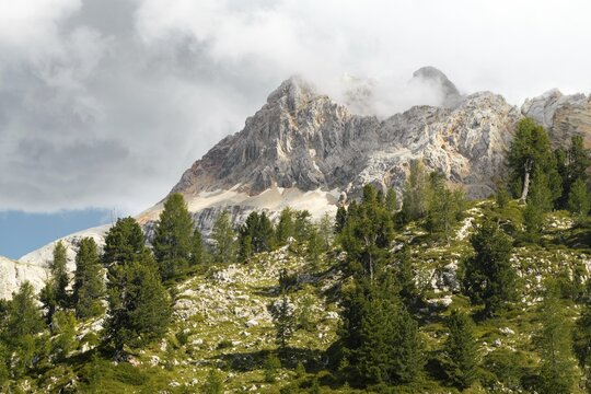 Dramatic mountain peaks colorful rocky scree slopes scenic alpine vista cloudy overcast sky mountain range background Malga Rossalm Dolomites South Tyrol Italy summer travel landscape