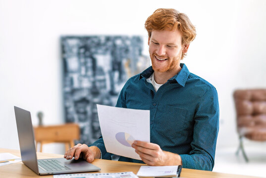 Smiling redhead businessman reviewing financial pie chart
