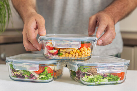 Man stacking healthy meal prep glass containers