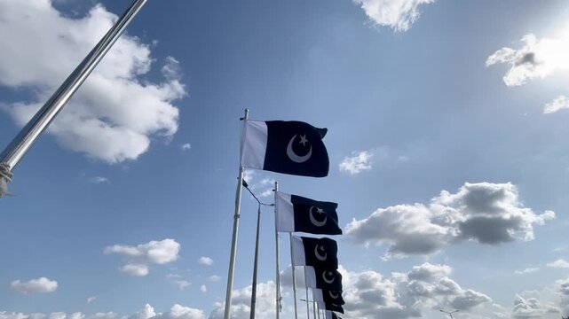 Pakistan flag waving in front of the blue sky. Country flag in motion, symbol of victory and patriotism
