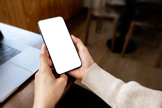 Woman holding modern smartphone with empty white screen mockup for mobile apps, branding and marketing. Close up of mobile device with clipping path for screen.