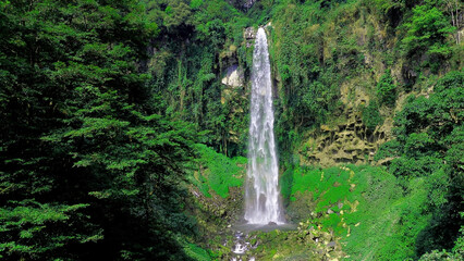 Aerial view of grojokan sewu Waterfall in Indonesia streaming down, cascades down steep, verdant cliffside, through dense jungle. Ideal for travel © faiz