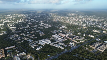Fototapeta premium Aerial view of Tulum town expansion and residential neighborhoods surrounded by dense jungle, Mexico