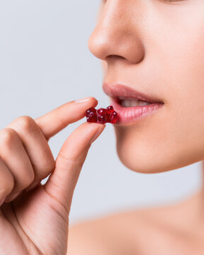 Woman hand holding gummy bear near lips, close up portrait of candy snack