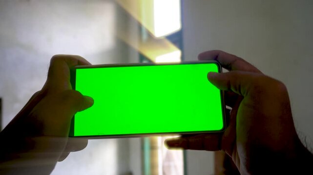 Dynamic zoom in and zoom out transition effect on a smartphone with a green screen display, capturing mobile gaming, application use, and digital technology concepts.