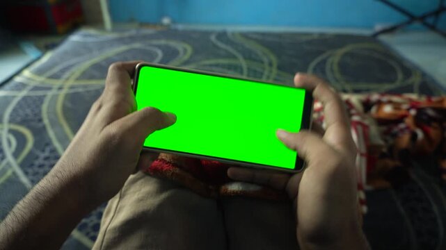 Dynamic zoom out and zoom in transition effect on a horizontal smartphone with a green screen display, capturing mobile gaming, application use, and digital technology concepts.