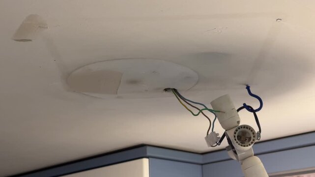 Handyman repairing the ceiling with a putty knife