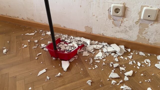 Someone sweeping up plaster debris after renovation