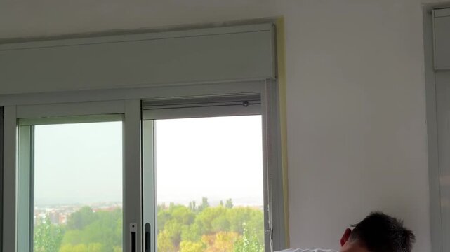 Man applying masking tape on a wall before painting