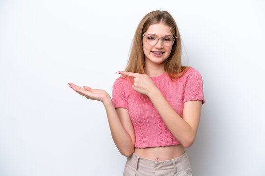 Teenager Russian girl isolated on white background holding copyspace imaginary on the palm to insert an ad