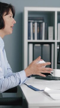 A woman is in an office looking exhausted while working at her desk. She checks her phone, rubs her eyes, and shows signs of fatigue as the day continues.