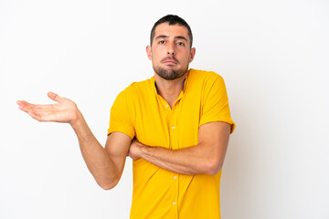 Fototapeta premium Young handsome caucasian man isolated on white background having doubts