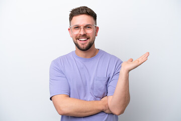 Fototapeta premium Young caucasian man isolated on white background holding copyspace imaginary on the palm to insert an ad