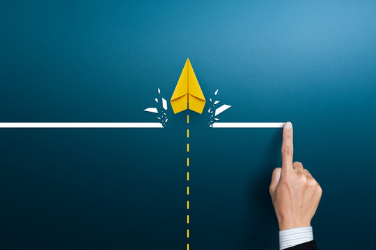 Yellow paper plane breaking through obstacle barrier line, business breakthrough and growth concept