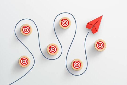 Red paper plane navigating a winding path to multiple business targets, strategic success concept