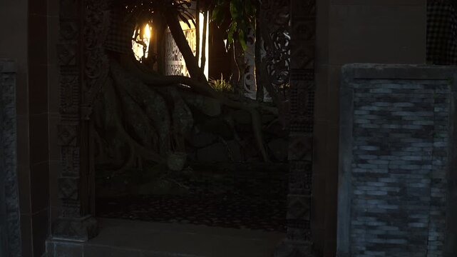 Traditional carved wooden frame and stone wall in a cozy illuminated garden setting in 4k video.