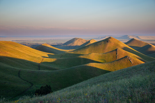 Summer sunset at Dolgiye Mountains in the Orenburg region, Russia. Hilly terrain, mountain fields. The beginning of the Ural Mountains.