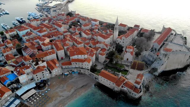 Aerial view of Budva Old Town featuring historic stone buildings, red rooftops and the Church of the Holy Trinity on the Adriatic coast of Montenegro.